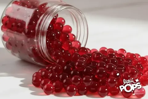 Tarro de perlas explosivas sabor chamoy junto a un vaso escarchado
