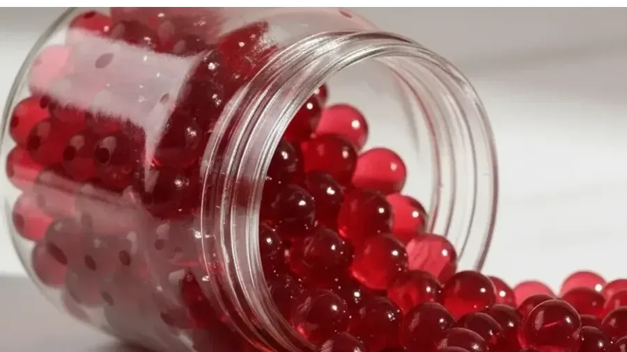 Perlas explosivas LiquiPops rojas saliendo de un frasco